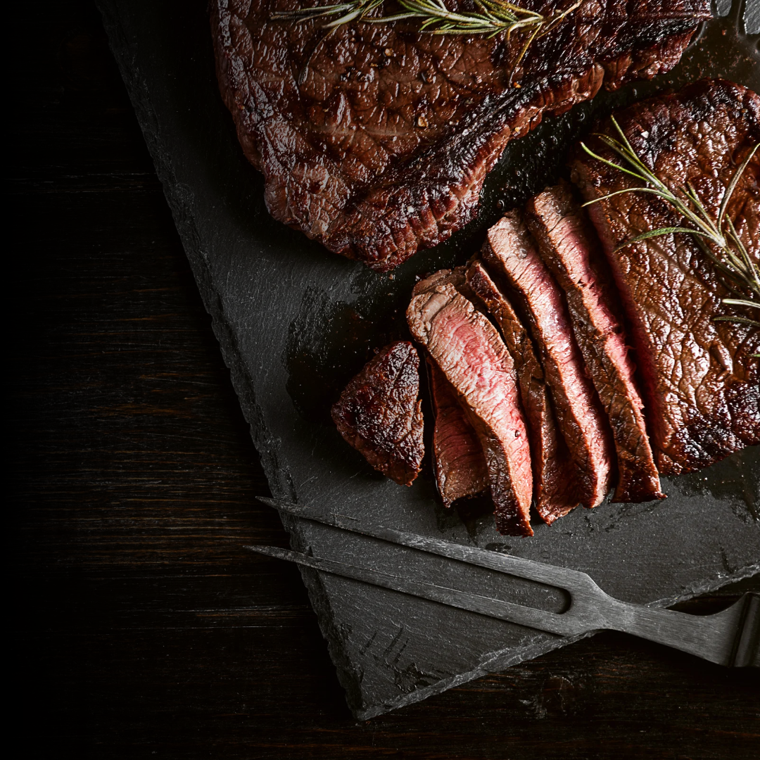 Sliced steak on a dark surface with a rustic background